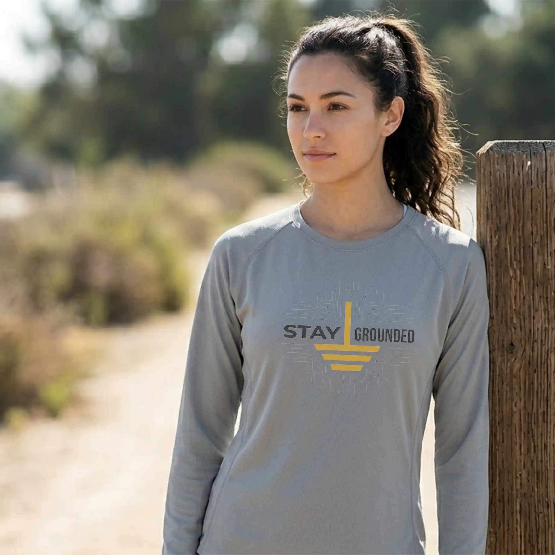 A female model wearing the long-sleeve Core365 CE10L moisture-wicking shirt in Platinum, showcasing the athletic fit and sun-protective coverage for outdoor training.